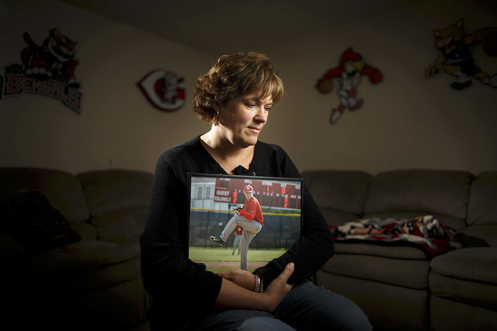 APortrait - 1st place   - Karen Ruf, 50, of Crestview Hills, poses with a favorite photo of her son, J.C., in the basement of her home in Crestview Hills, Ky. Ruf refers to the basement den as her son's "man cave" where he would gather with friends to watch movies and play video games. J.C. killed himself in October 2016, leaving only a short note, leaving his mother with more questions than answers. Karen has since devoted herself to suicide awareness. (Sam Greene / Cincinnati Enquirer)